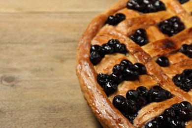 Photo of Tasty homemade pie with blueberries on wooden table, closeup. Space for text