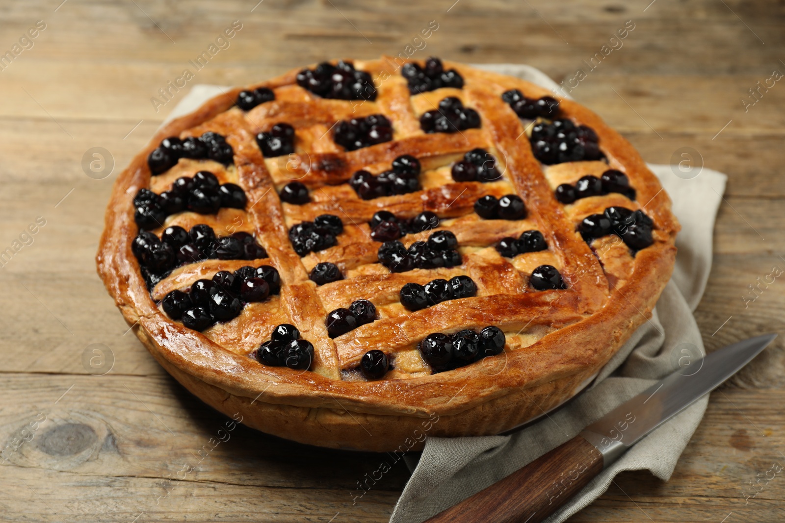 Photo of Tasty homemade pie with blueberries and knife on wooden table