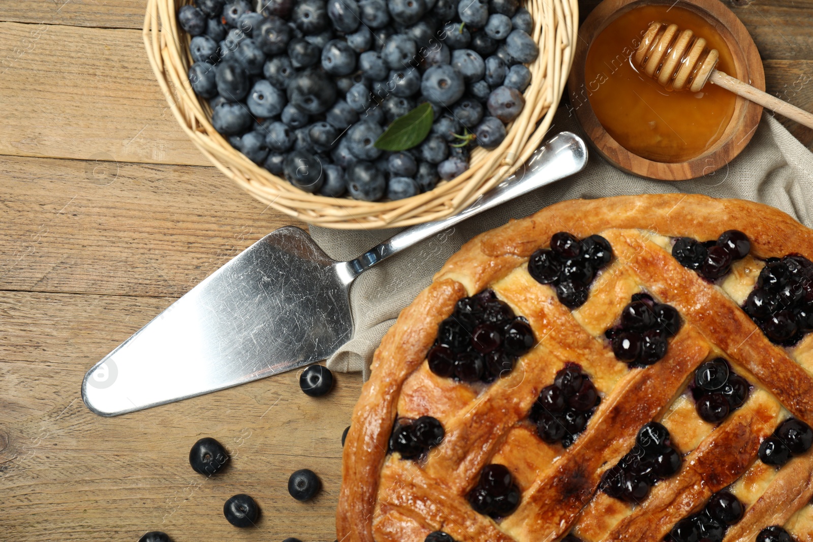 Photo of Tasty homemade pie with blueberries served on wooden table, flat lay