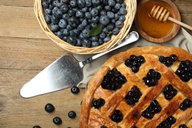 Photo of Tasty homemade pie with blueberries served on wooden table, flat lay