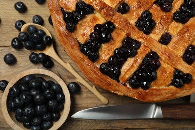 Photo of Tasty homemade pie with blueberries served on wooden table, flat lay