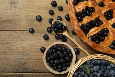 Photo of Tasty homemade pie with blueberries served on wooden table, flat lay