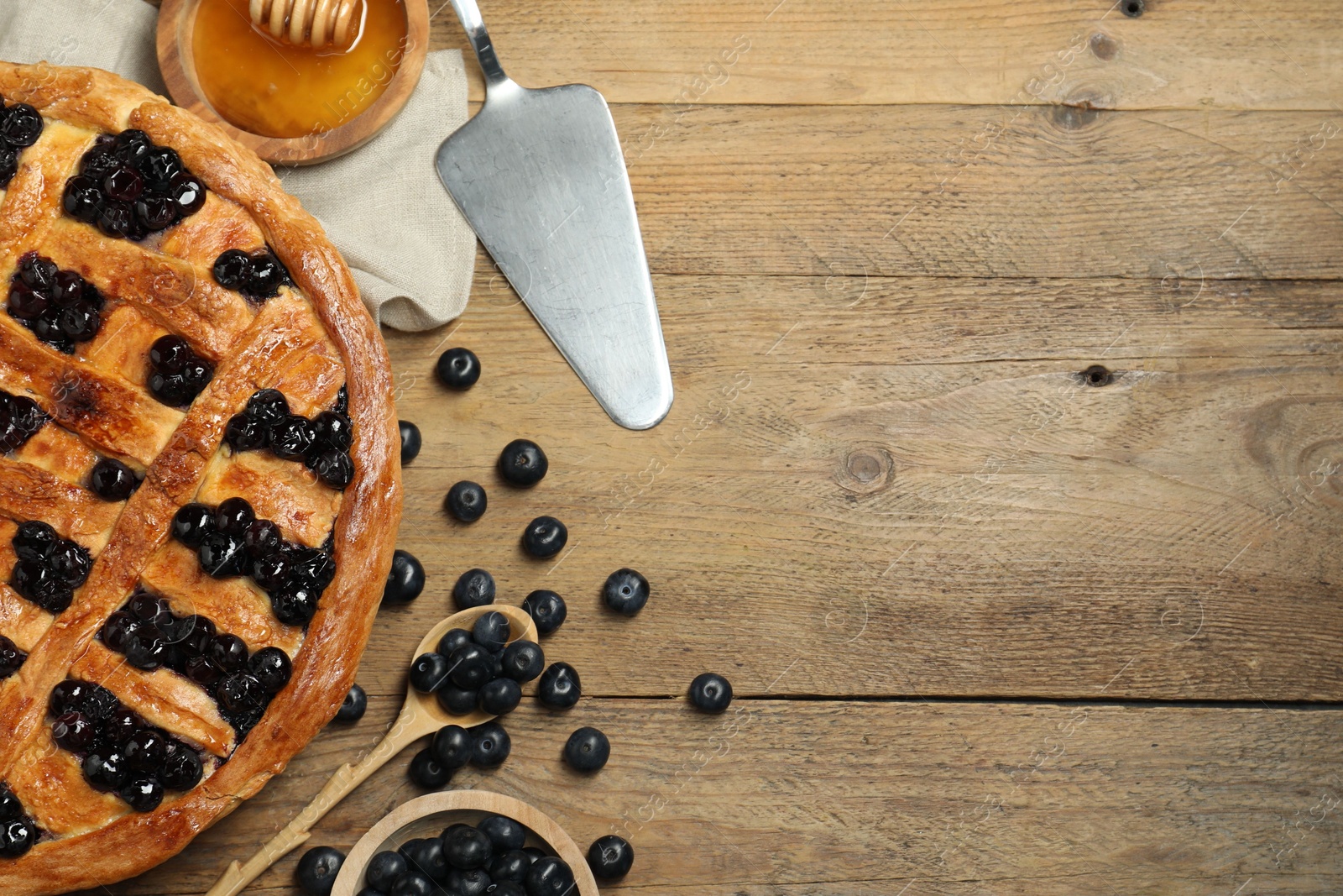 Photo of Tasty homemade pie with blueberries served on wooden table, flat lay. Space for text