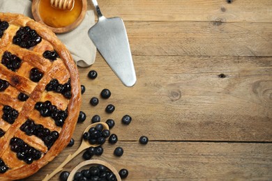 Photo of Tasty homemade pie with blueberries served on wooden table, flat lay. Space for text