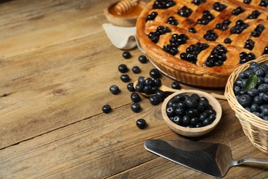 Photo of Tasty homemade pie with blueberries served on wooden table. Space for text