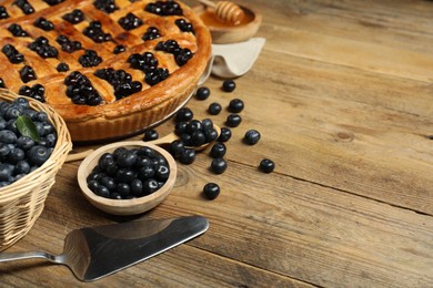 Photo of Tasty homemade pie with blueberries served on wooden table. Space for text