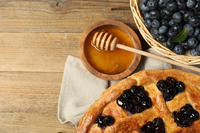 Photo of Tasty homemade pie with blueberries served on wooden table, flat lay. Space for text