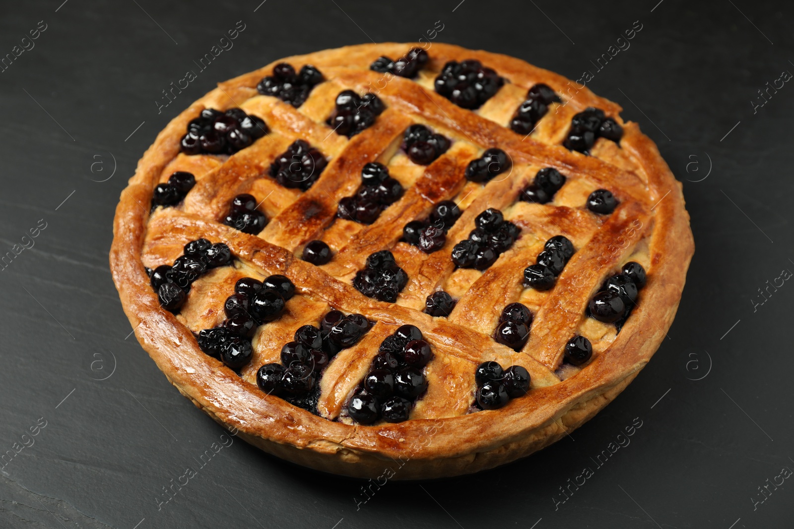 Photo of Tasty homemade pie with blueberries on grey textured table, closeup