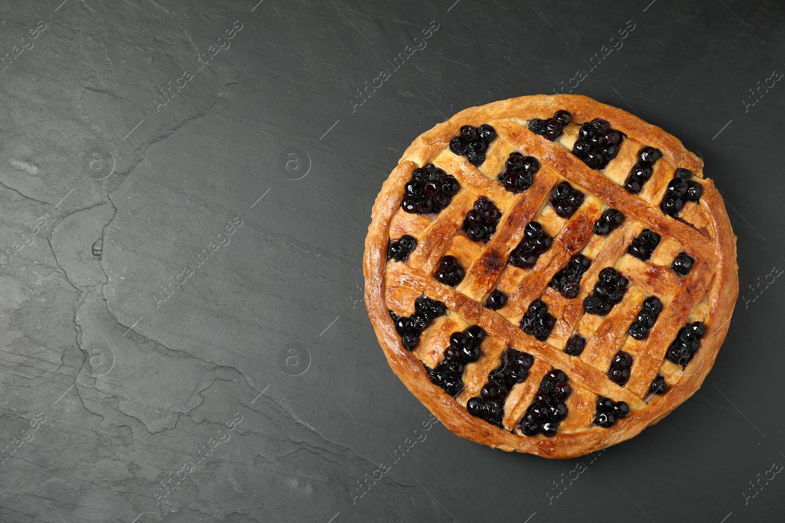 Photo of Tasty homemade pie with blueberries on grey textured table, top view. Space for text