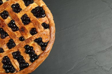 Photo of Tasty homemade pie with blueberries on grey textured table, top view. Space for text