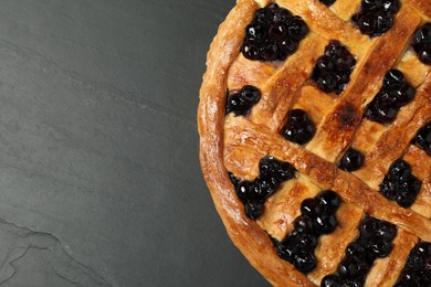 Photo of Tasty homemade pie with blueberries on grey textured table, top view. Space for text