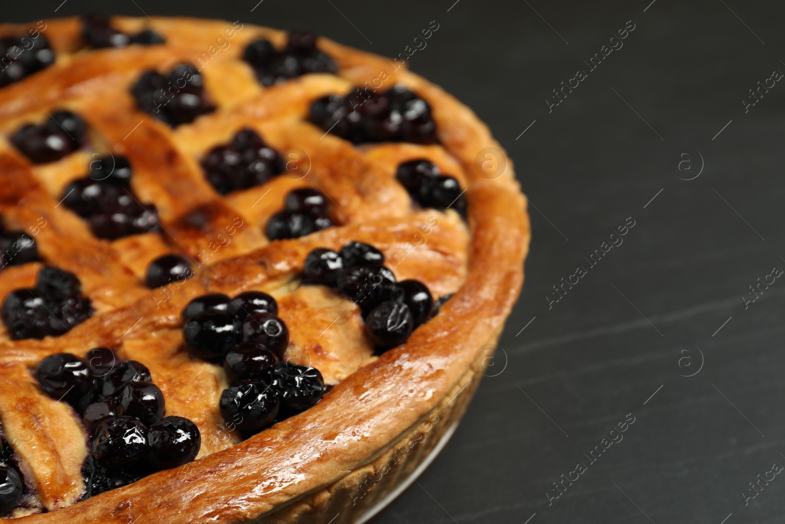 Photo of Tasty homemade pie with blueberries on grey table, closeup. Space for text