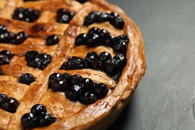 Photo of Tasty homemade pie with blueberries on grey table, closeup