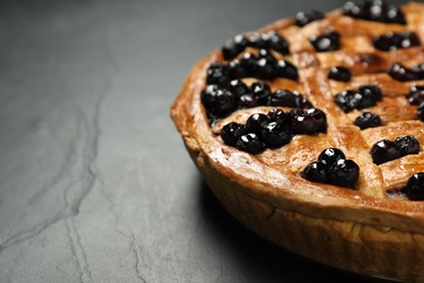 Photo of Tasty homemade pie with blueberries on grey table, closeup. Space for text