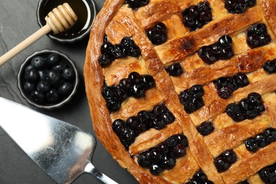 Photo of Tasty homemade pie with blueberries served on grey table, flat lay