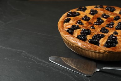 Photo of Tasty homemade pie with blueberries served on grey textured table, closeup. Space for text