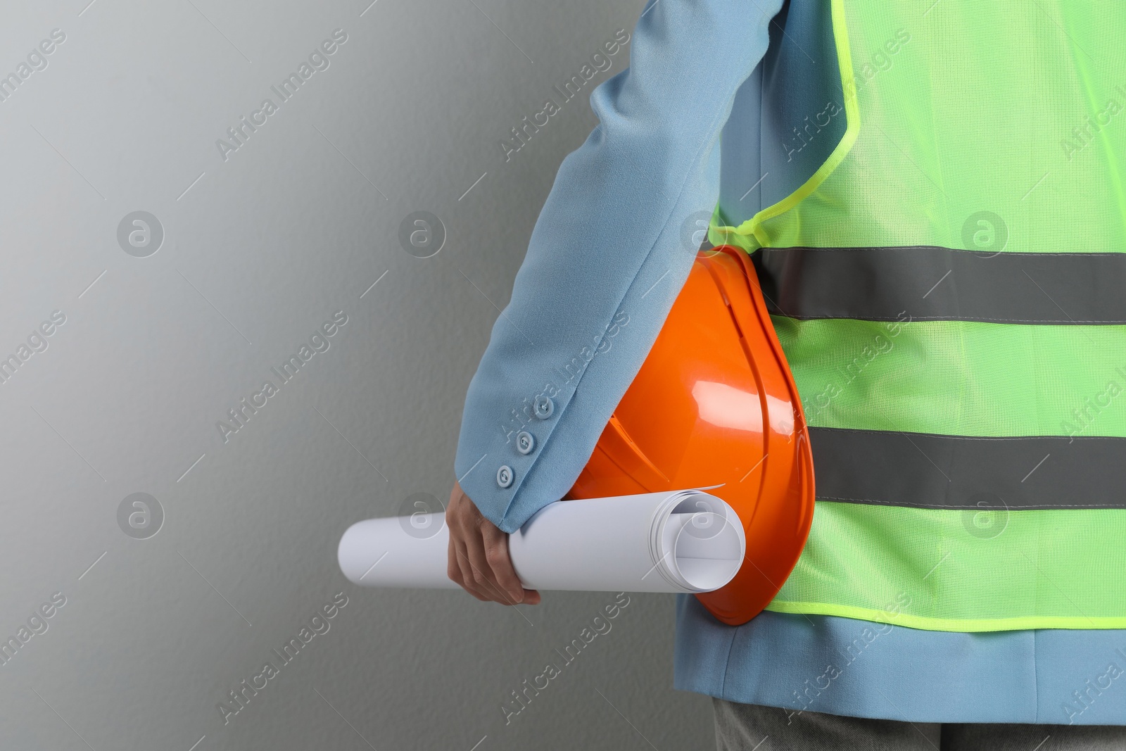 Photo of Engineer with hard hat and draft on grey background, closeup. Space for text