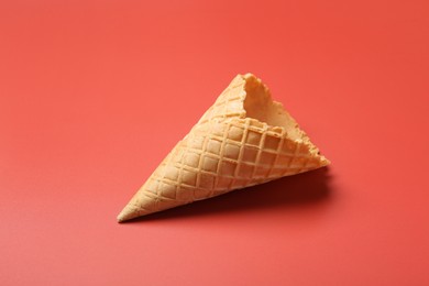 Photo of Empty wafer ice cream cone on pale pink background