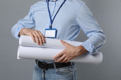 Photo of Engineer with drafts on grey background, closeup