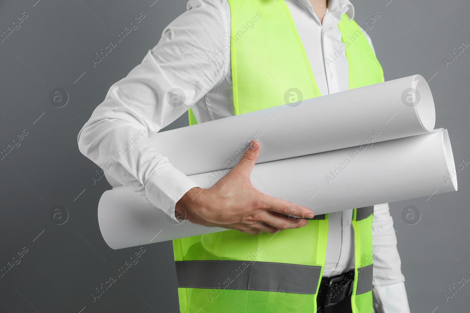 Photo of Engineer hat with drafts on grey background, closeup