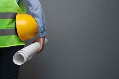 Photo of Engineer with hard hat and draft on grey background, closeup. Space for text