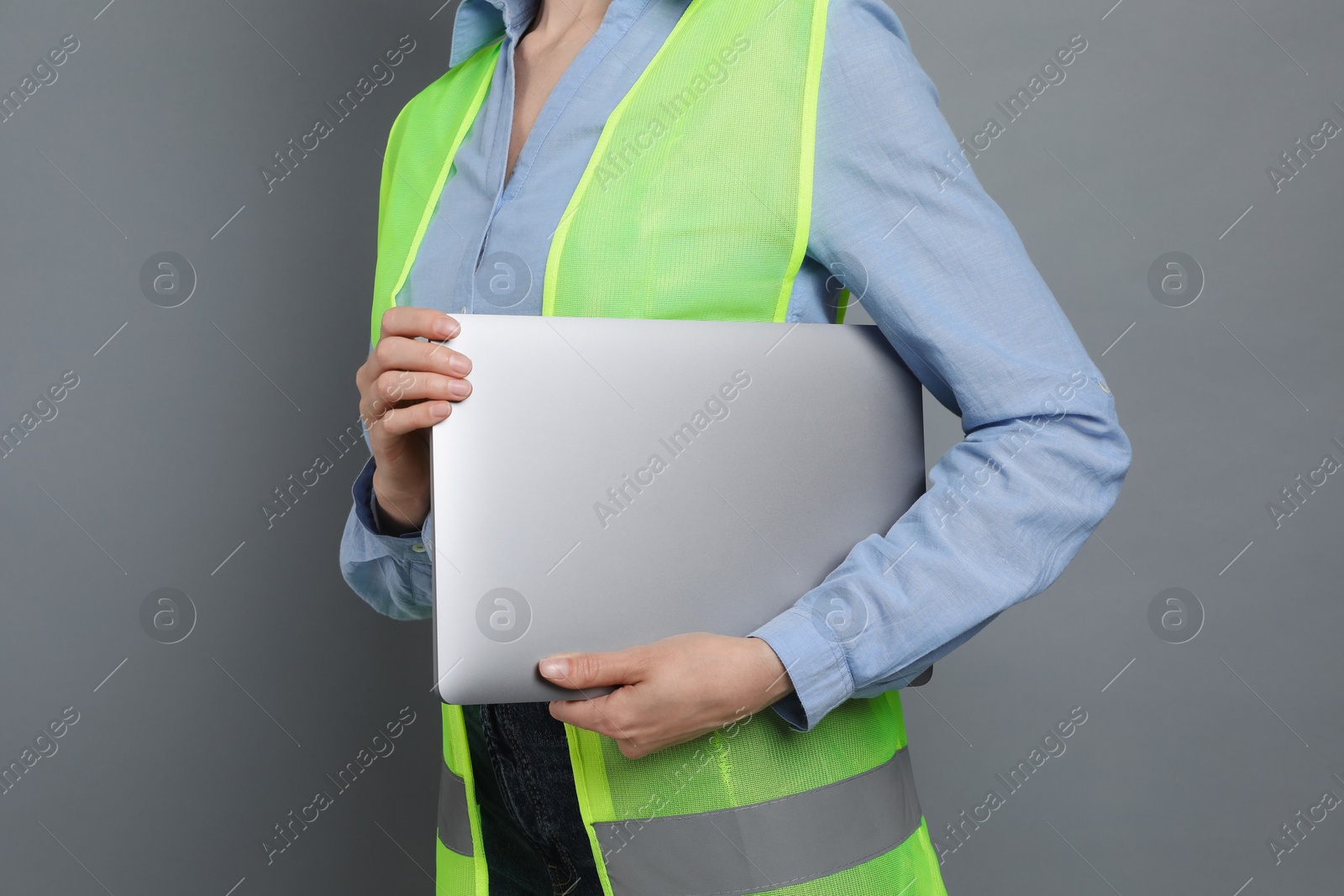 Photo of Engineer with laptop on grey background, closeup