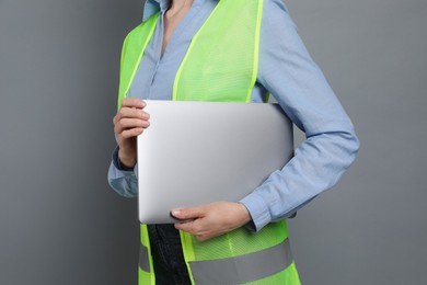 Engineer with laptop on grey background, closeup