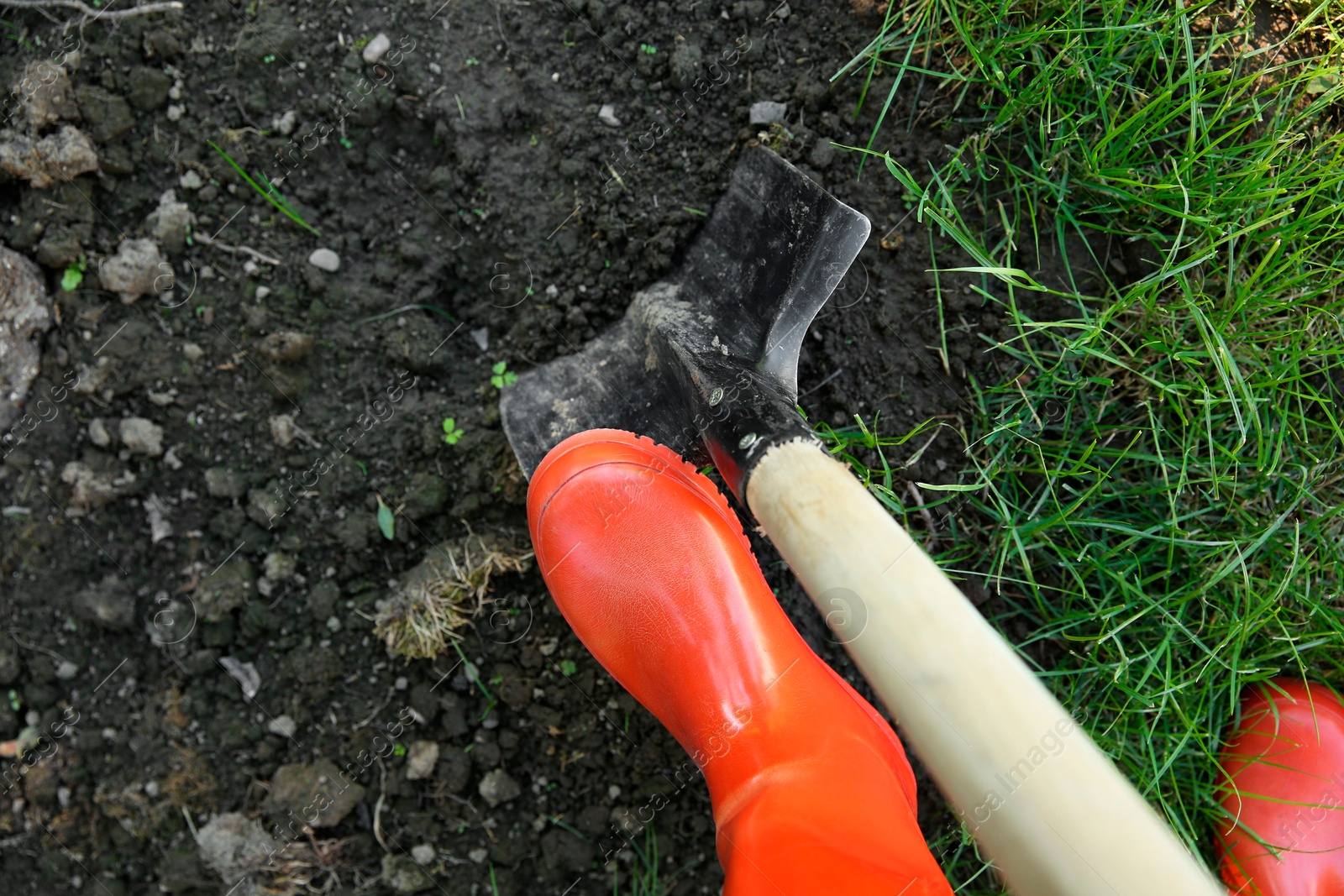 Photo of Farmer digging soil with shovel, above view