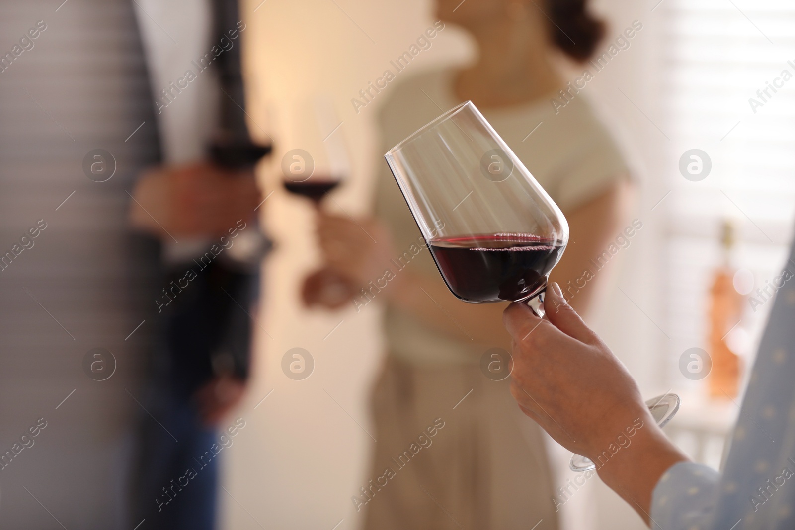 Photo of Woman with glass of red wine indoors, selective focus