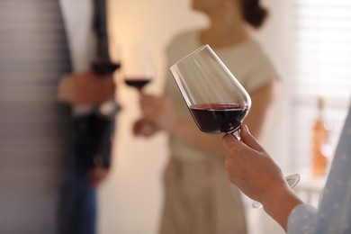 Photo of Woman with glass of red wine indoors, selective focus