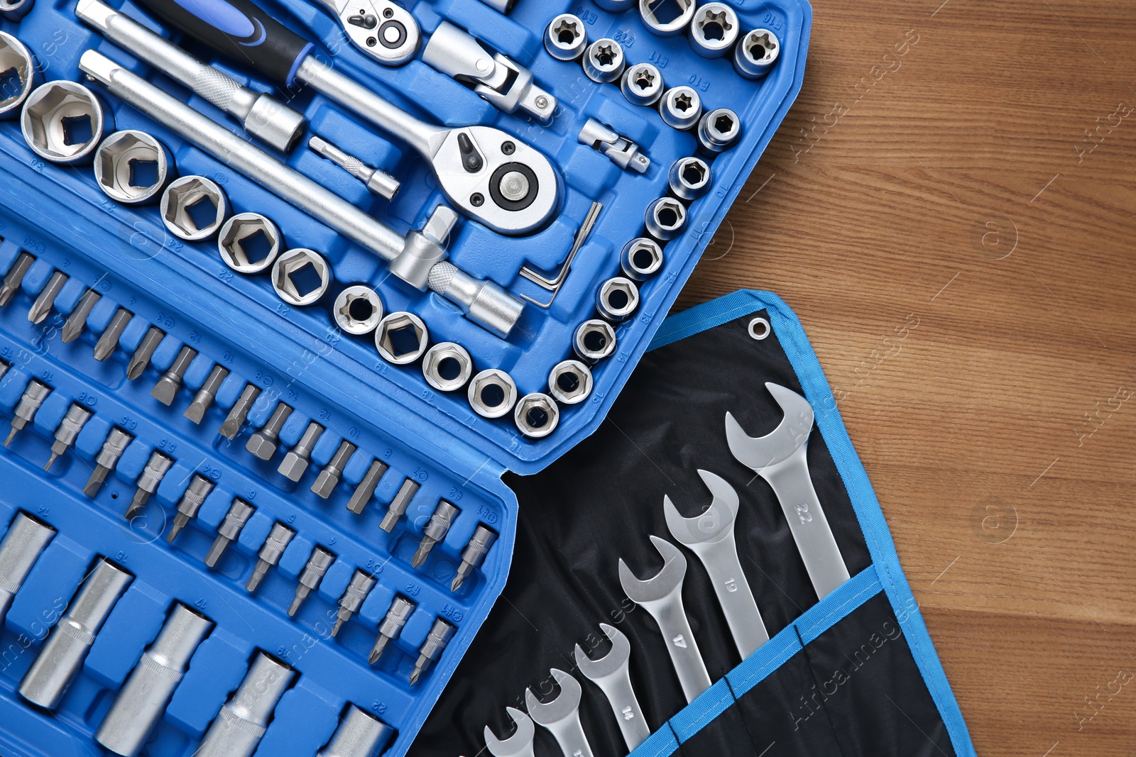 Photo of Different auto mechanic's tools on wooden table, top view