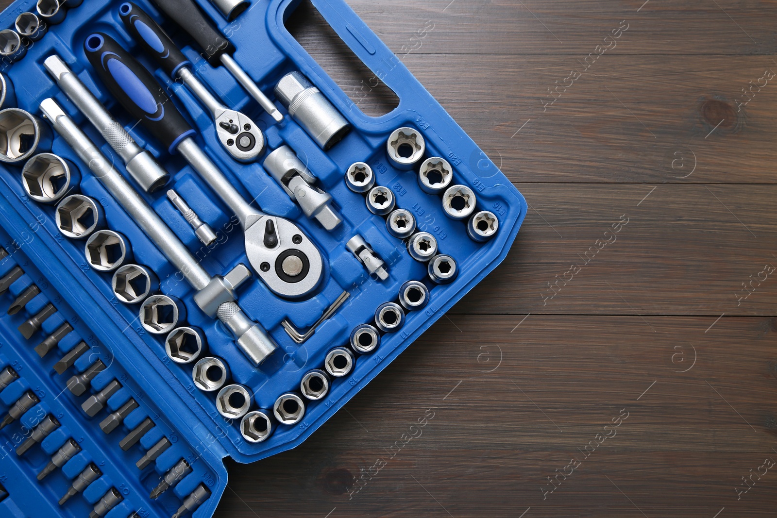 Photo of Auto mechanic's tools in plastic box on wooden table, top view. Space for text