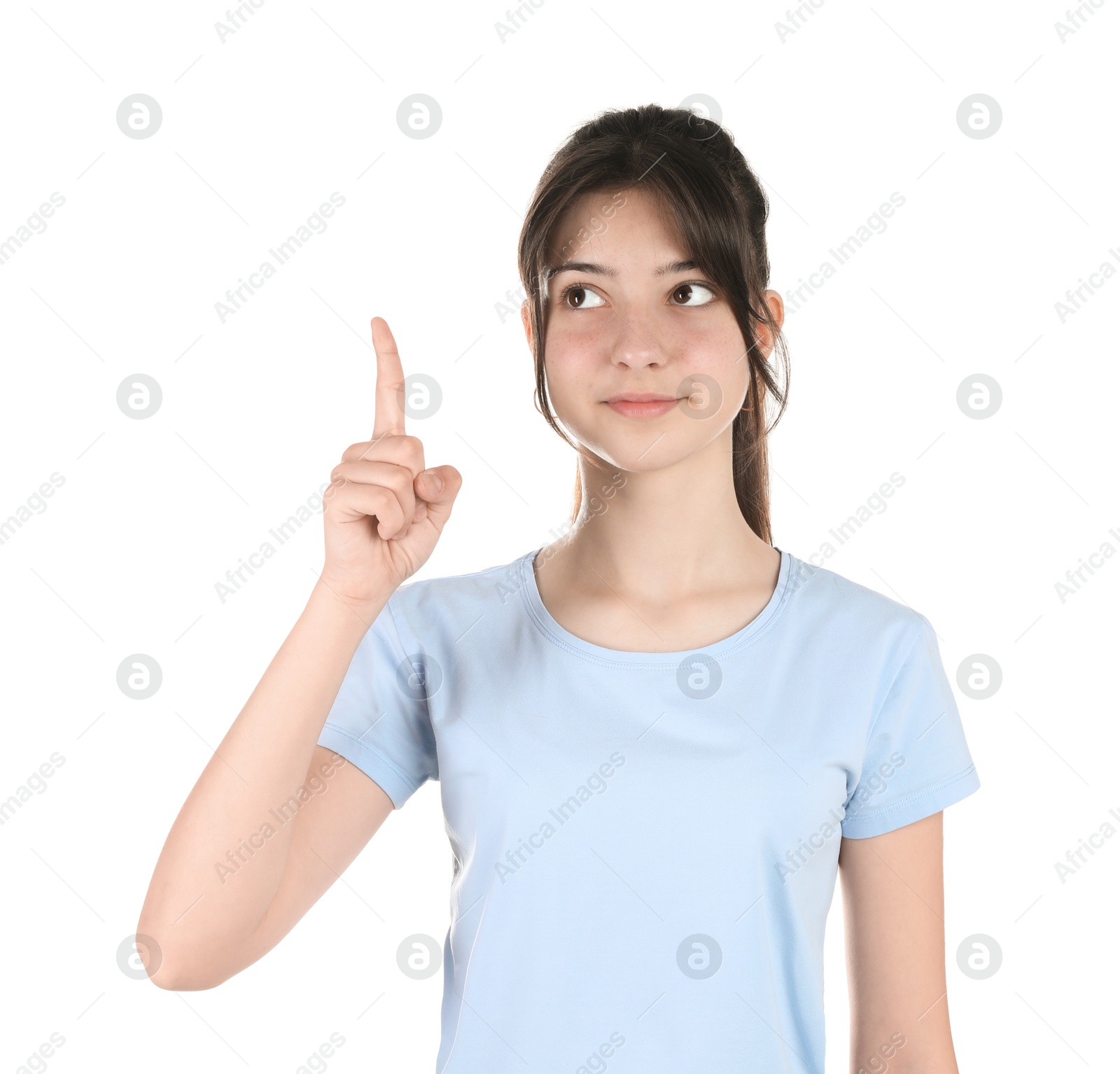 Photo of Portrait of cute teenage girl pointing at something on white background