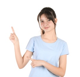 Portrait of cute teenage girl pointing at something on white background