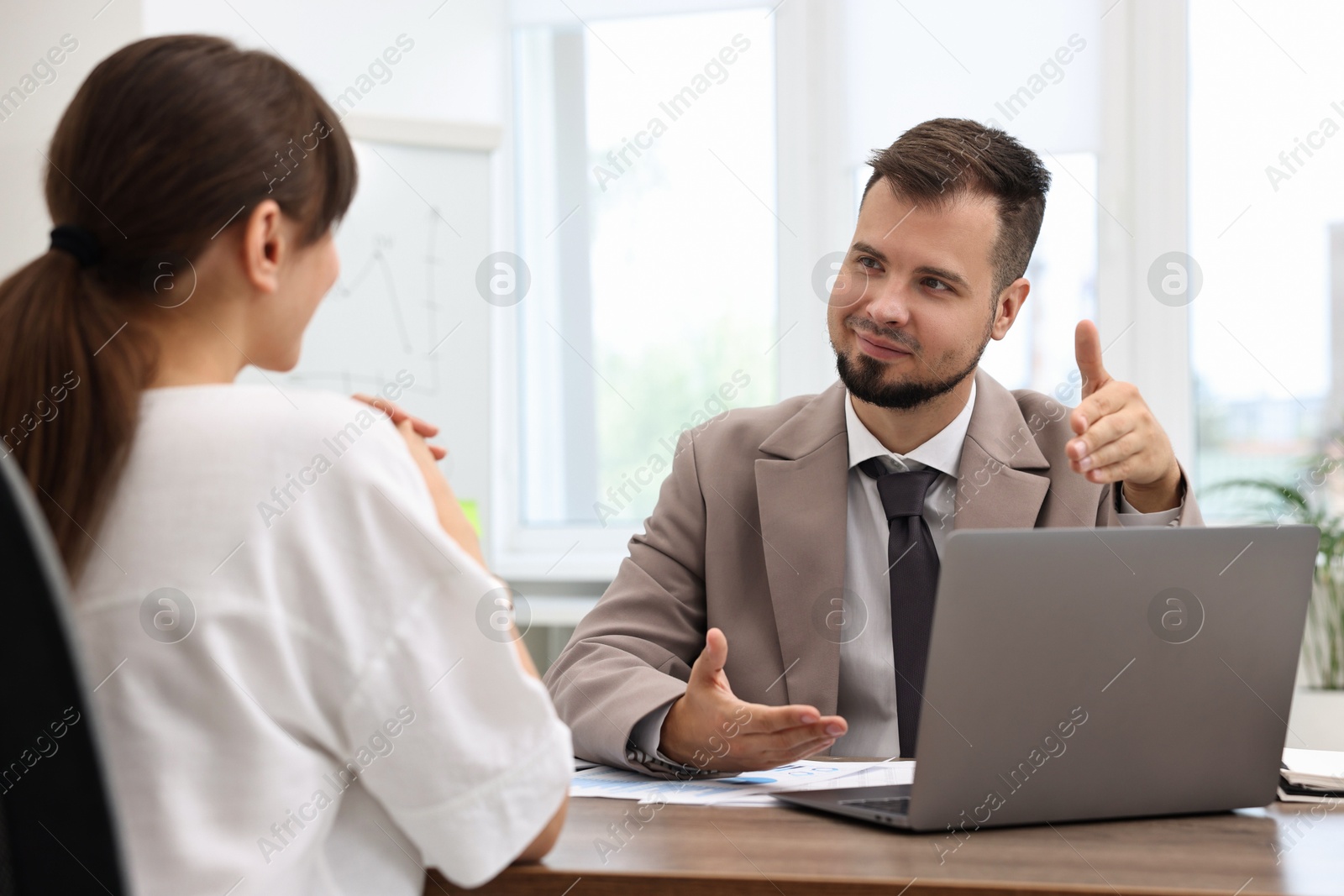 Photo of Consultant working with client at table in office. Business meeting