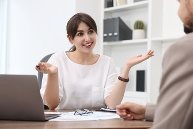 Smiling consultant working with client at table in office. Business meeting