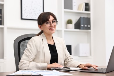 Portrait of smiling business consultant at table in office