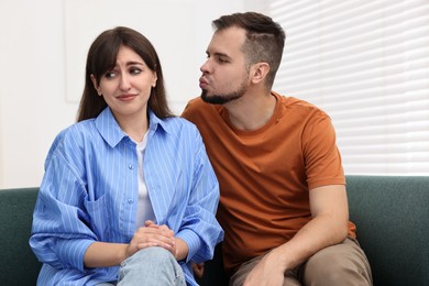 Man trying to kiss embarrassed woman at home