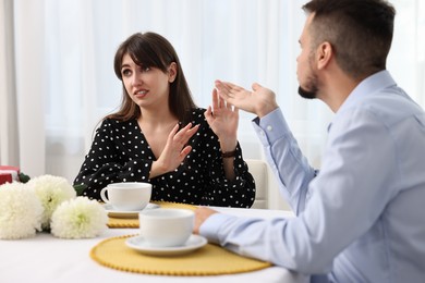 Photo of Man sending air kiss to embarrassed woman at home