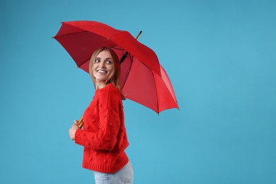 Woman with red umbrella on light blue background