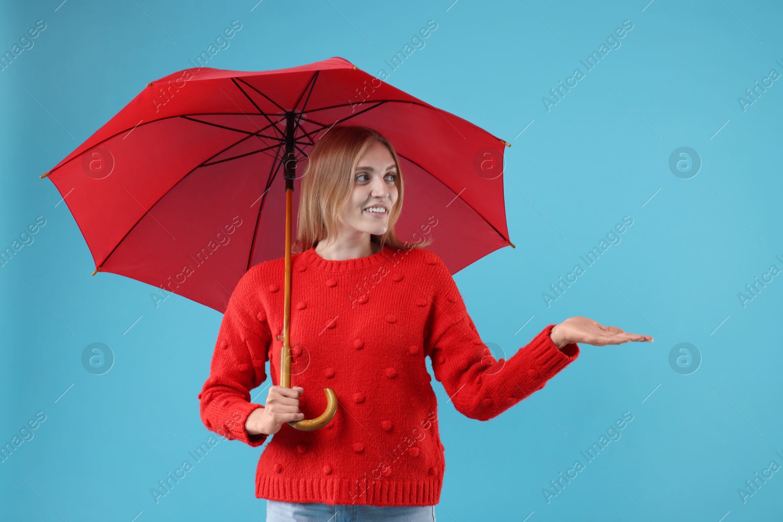 Photo of Woman with red umbrella on light blue background