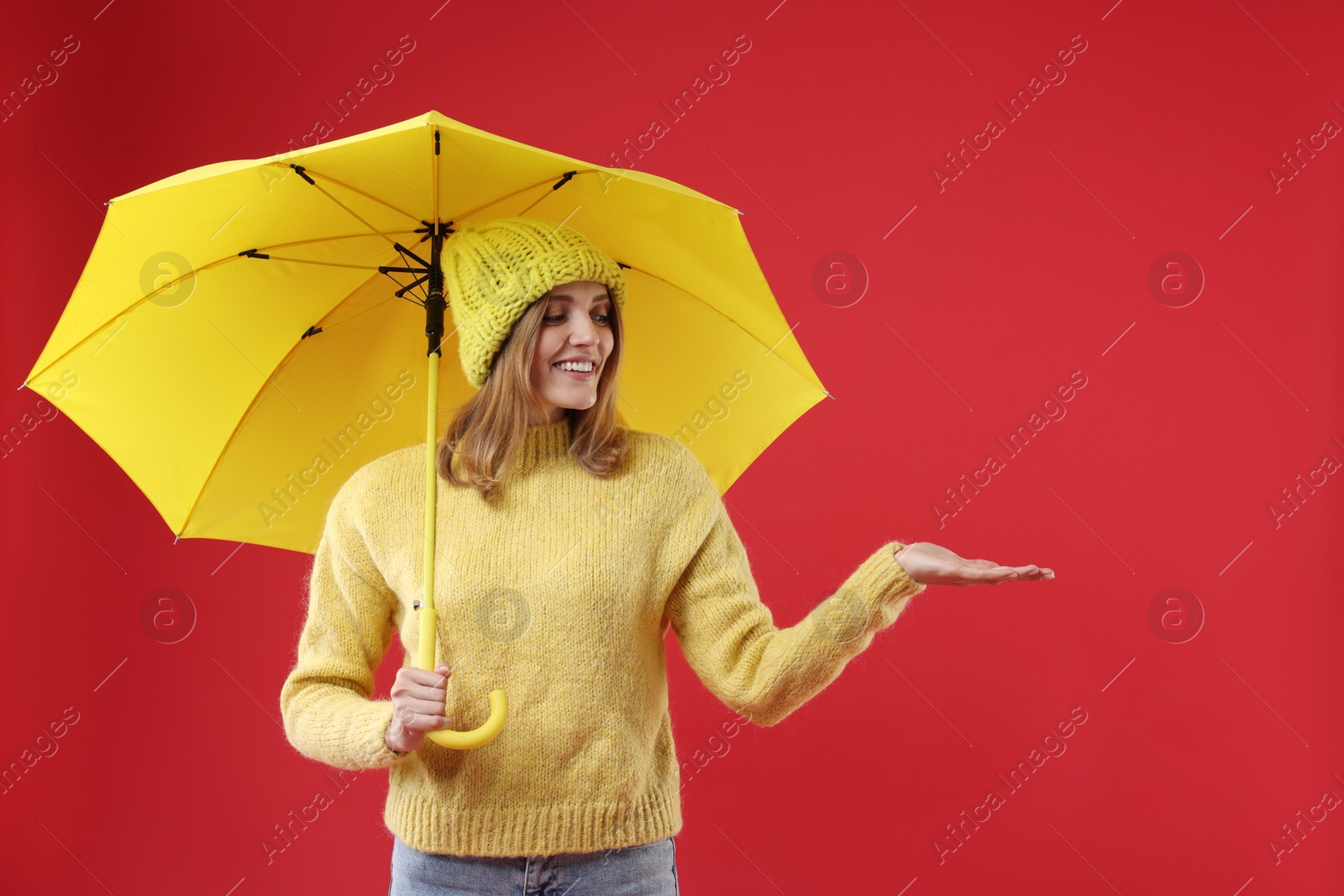 Photo of Woman with yellow umbrella on red background, space for text