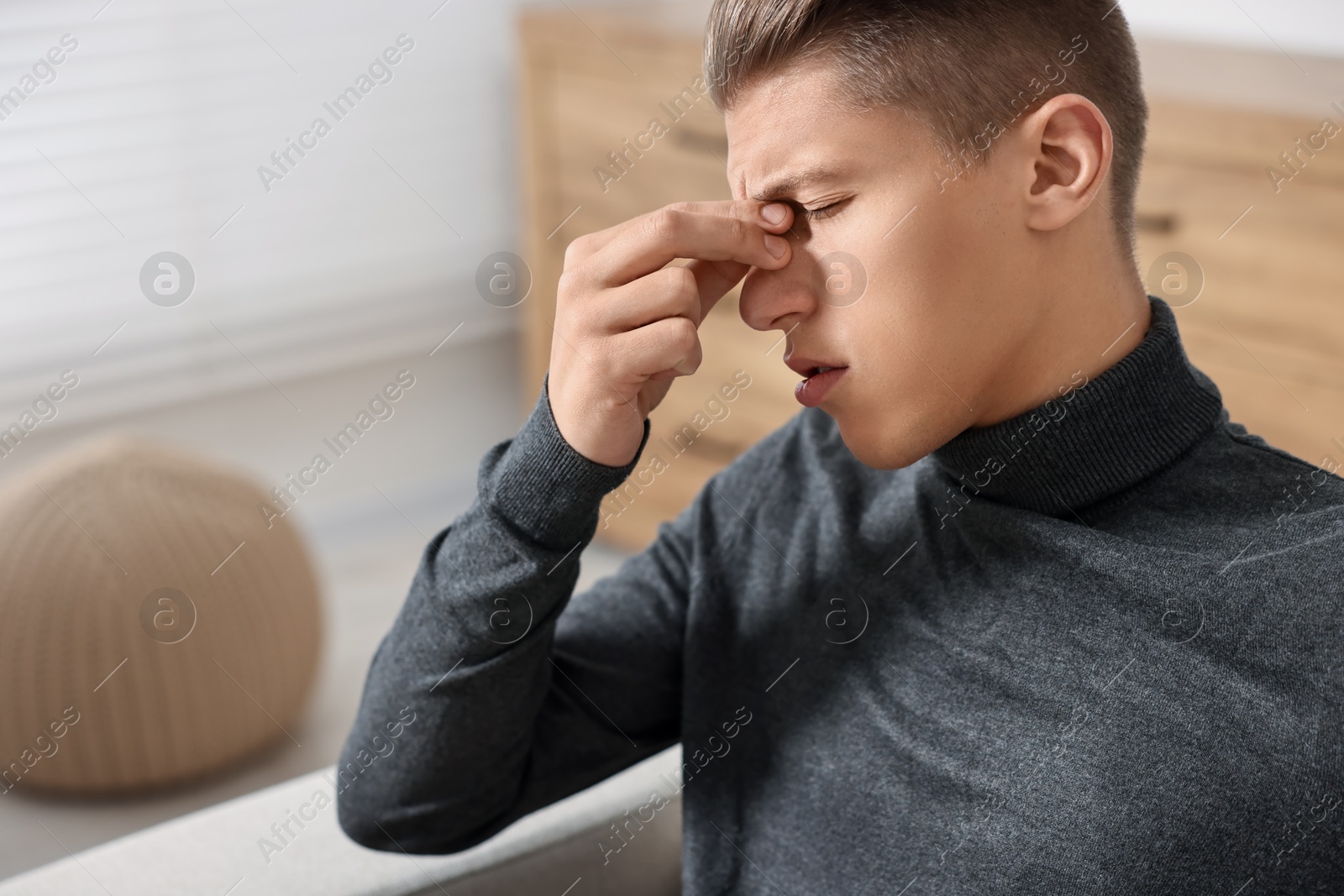 Photo of Young man suffering from sinusitis at home