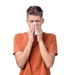 Young man with tissue suffering from sinusitis on white background