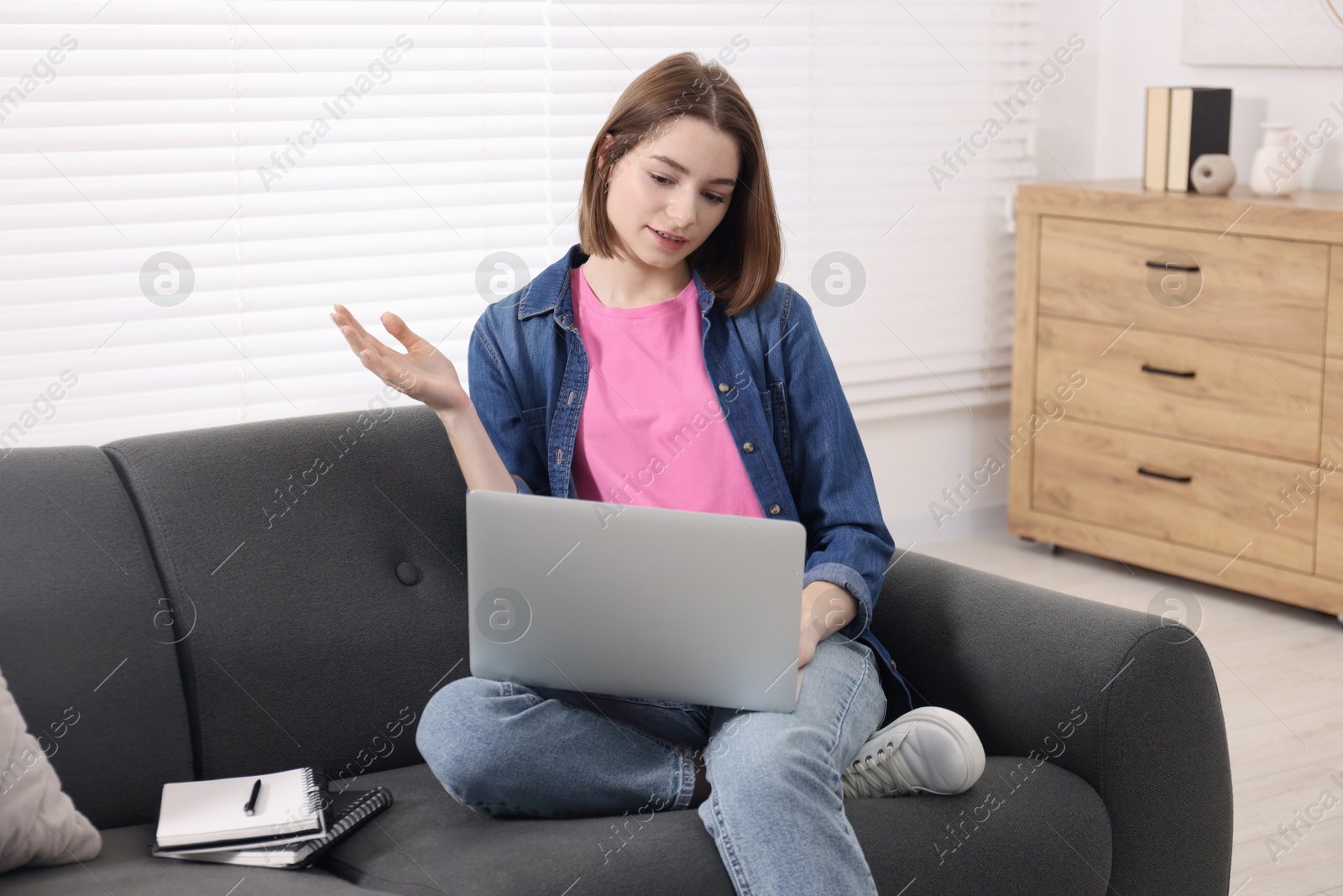 Photo of Teenager having video chat via laptop at home. Remote work