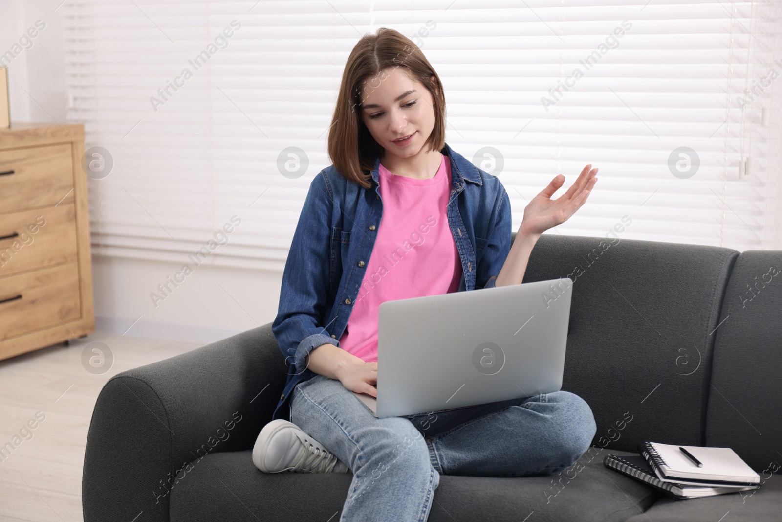 Photo of Teenager having video chat via laptop at home. Remote work