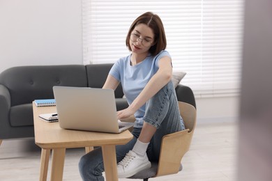 Teenager working with laptop at home. Remote job