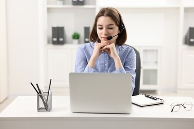 Teenager in headset having video chat via laptop at home. Remote work