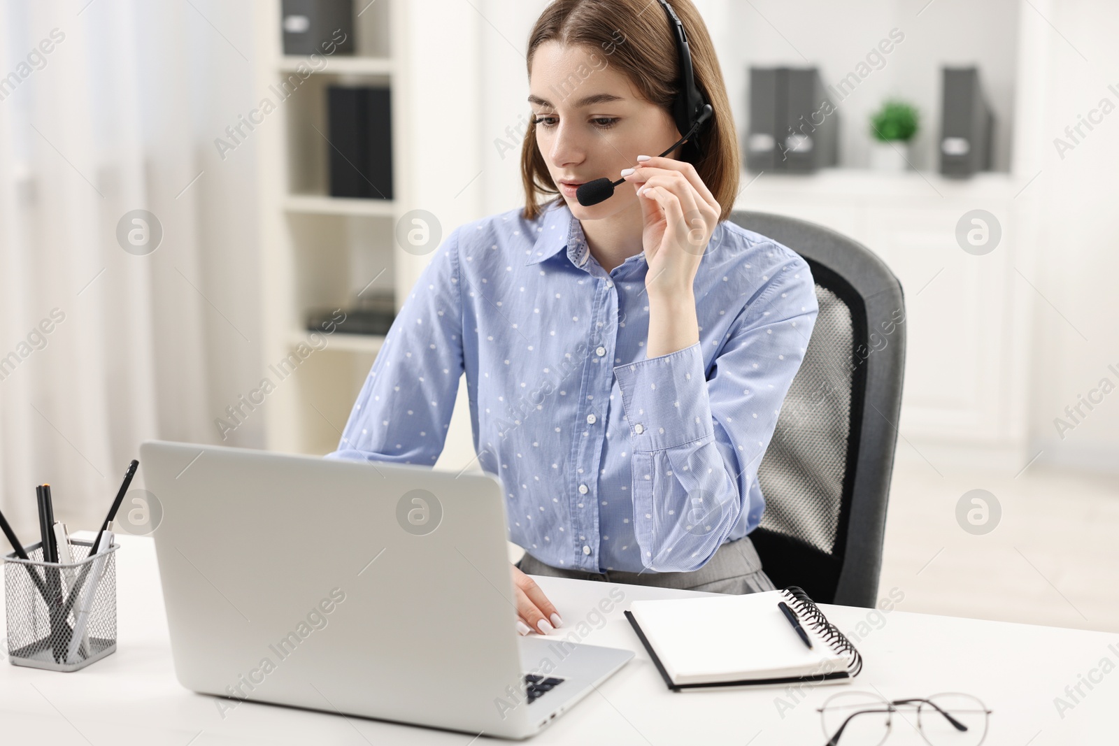 Photo of Teenager in headset having video chat via laptop at home. Remote work