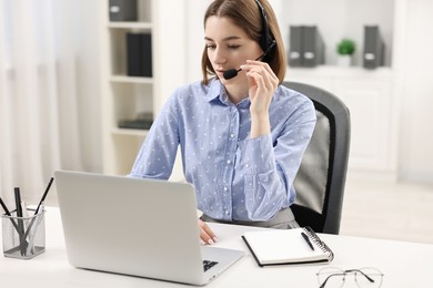 Teenager in headset having video chat via laptop at home. Remote work